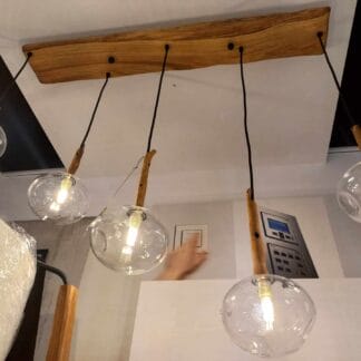 Lampa wisząca na drewnianej podsufitce z przezroczystymi kulami ze szkła